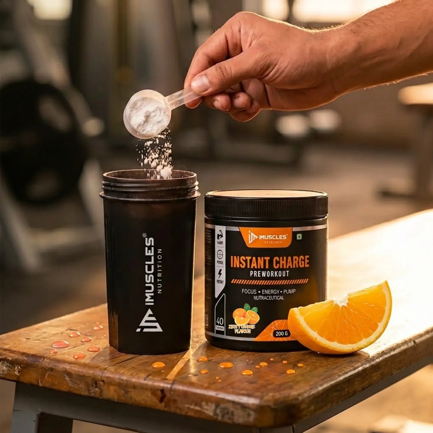 A promotional image titled "Zesty Orange 7.jpg" shows a hand pouring a scoop of powder into an iMuscles Nutrition shaker bottle next to an "INSTANT CHARGE" pre-workout jar and a fresh orange slice on a wooden bench, symbolizing the preparation of a high-performance supplement in a gym setting.