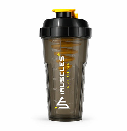 A promotional banner for iMuscles Nutrition, referenced as 7.1.jpg. The left side features bold text reading "LOVED AND RECOMMENDED BY THOUSANDS" followed by the tagline "Fuel Your Fitness. Shake Smarter With iMuscles." The right side shows a collage of lifestyle settings, with the central focus on a sleek, dark translucent iMuscles shaker bottle resting on a gym bench. Other background elements include a home office setup and a yoga mat with a bowl of fruit.