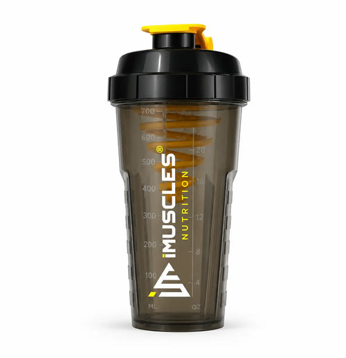 A promotional banner for iMuscles Nutrition, referenced as 7.1.jpg. The left side features bold text reading "LOVED AND RECOMMENDED BY THOUSANDS" followed by the tagline "Fuel Your Fitness. Shake Smarter With iMuscles." The right side shows a collage of lifestyle settings, with the central focus on a sleek, dark translucent iMuscles shaker bottle resting on a gym bench. Other background elements include a home office setup and a yoga mat with a bowl of fruit.