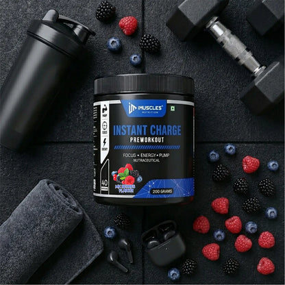 A square digital product promotional image titled "Mix Berries 13.jpg" featuring an iMuscles Nutrition "INSTANT CHARGE" pre-workout jar centered on a dark gym floor. The scene is accessorized with a black shaker, a gym towel, dumbbells, and wireless earbuds, all surrounded by scattered fresh raspberries, blackberries, and blueberries.