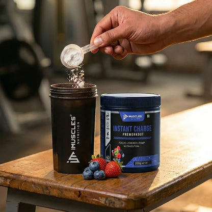 A square digital product promotional image titled "Mix Berries 7.jpg" showing a hand pouring a scoop of white pre-workout powder into a black iMuscles Nutrition shaker. Next to the shaker is an iMuscles Nutrition "INSTANT CHARGE" pre-workout jar and a small pile of fresh strawberries and blueberries on a wooden bench in a gym setting.