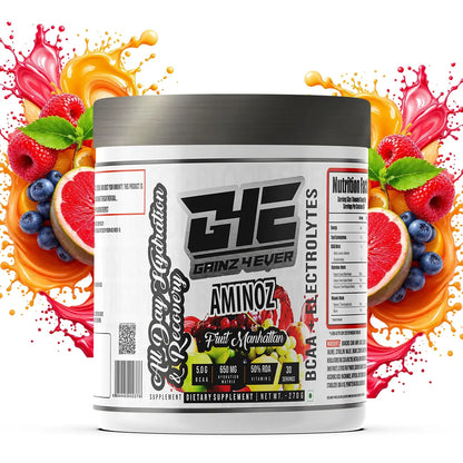 Promotional image for GAINZ 4 EVER AMINOZ Fruit Manhattan flavor. The white 270g supplement jar is positioned in the center, surrounded by vibrant splashes of red and orange liquid, fresh raspberries, blueberries, grapefruit slices, and grapes. The label highlights "BCAA + ELECTROLYTES" and "All Day Hydration & Recovery" with 30 servings per container.